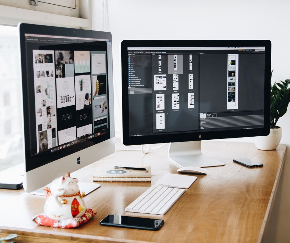 Website design layouts displayed on two desktop computers